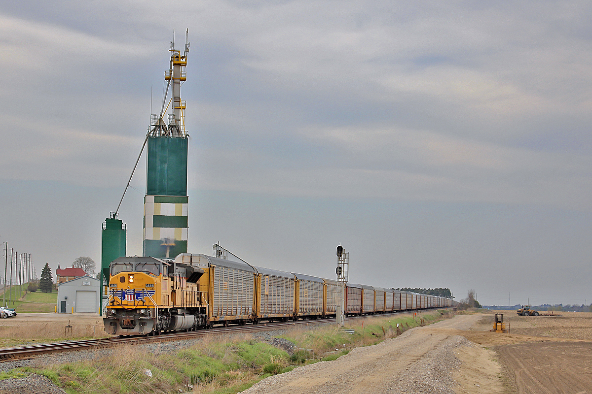 I had just recently gotten surgery on my left arm, and less than a week later, I unfortunately had a reason to drive. I had been tracking this consist for two days pleading it would come during daylight. I lost track, and found out it left MacTier at 1353. So with one arm, I drove from St. Catharines to Ypres, hoping to catch at wrap around the corner there. I noticed autoracks down the track in the siding at Baxter, and it was quite clear to me it was that extra 420. The rush was unnecessary though, as CP 119 had to go through, 421 needed to finish up at Spence, and the Honda Job needed to do work there as well. After almost two and a half hours, 9-420-03 finally got under way. Merging back onto the single main, UP 3655 leads 72 multis past the Cargill elevator at Baxter's south siding switch. Next stop is Spence, where it will drop its entire train, and head light to Toronto yard. I did not appreciate the overcast lighting, but I had to take what I got. Thankfully the scene is fitting, and is almost deceptive as if this was taken in Iowa or Nebraska. It wasn't. After seeing FPON's lead trains numerous times, this would be the first time I actually got a reasonable shot of this sort of event.