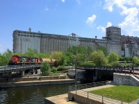 CN 7015 & CN 7246 are inbound into the Port of Montreal as they cross the Lachine canal. Behind them is the massive Grain elevator #5, out of use for about twenty years now. The first section of the elevator was built by the Grand Trunk Railway.