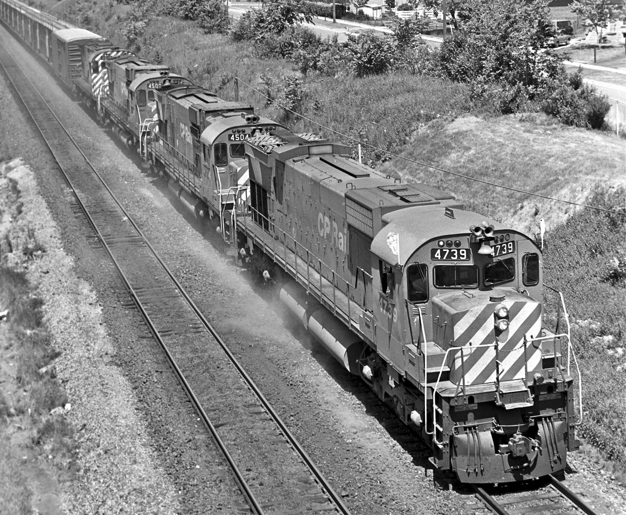 With her “Extra” flags straining, M-636 #4739 leads the charge through Scarborough, circa 1976.  Built by MLW six years earlier, the locomotive was retired in ’93, un-retired in ’94, and re-retired in ’95.


Check out Timothy Wakeman’s great shot of #4739 taken in 1987…


http://www.railpictures.ca/?attachment_id=15057


The second and third units are a couple of C-630’s.  Both were built in 1968.  #4504 served until ’91.  #4500 lasted with the CPR until 1993.  She was then donated to the York-Durham Heritage Railway Society in Uxbridge, Ontario.  Shortly thereafter the locomotive ended up south of the 49th.