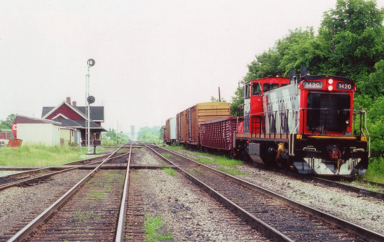 On a steamy hot July day I stopped by Merritton yard to see what was happening. Nothing. The air is thick, no breeze, and not the kind of day I wanted to hang around sweating. And besides, in the distance one can see the Welland Canal bridge is in the up position. Nice to see CN 1420 resting between jobs on the siding as perhaps the crew had taken a break for lunch; and because of that, I wandered down to the tracks for a photo. Glad I did. The 1420 is long gone from the area and the station burned down a few years after this shot was taken. As far as the 1420 goes, it had been remanufactured and renumbered from #1058 in 1989. Designated now as a GMDlu. It is still around...somewhere.