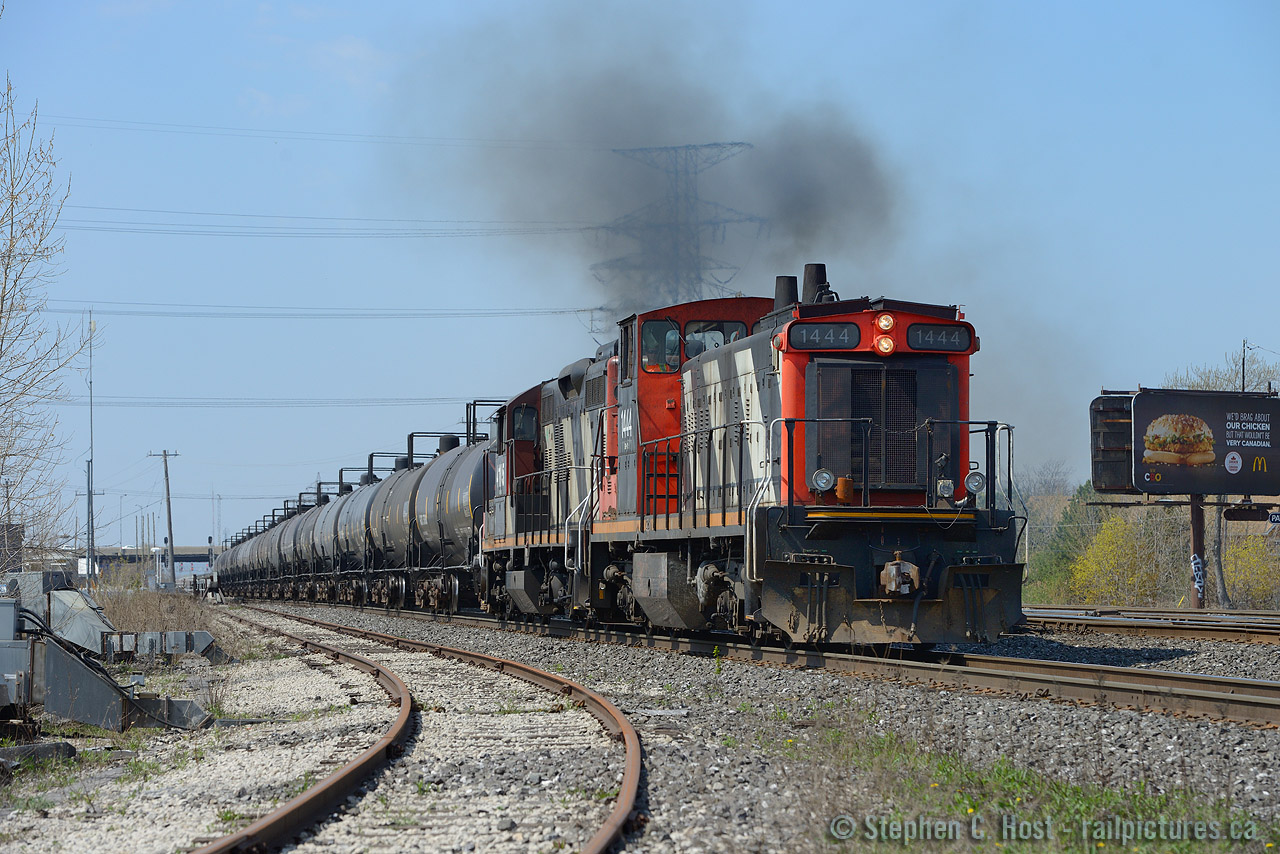 Seeing Del Rosamond and Arnold Mooneys photos of Quintessential GMD1's in the 50's and 80's posted today on rp.ca, makes you realize how lucky we are to have these 1st generation diesels kicking around considering their heritage. Let me set the scene - I was lucky to get this shot.
I'm on the QEW heading back from my Brothers, heading north, when I hear PRH on the radio talking to 547, who is calling for a light. 547: "YO we're looking to get out on the main, work at Burloak".  PRH: "And what is your lead engine number?" 547: "one triple four." PRH: "And your TIBS equipped". 547: "Yes we are". PRH: "OK to proceed on signal indication". Knowing what a TIBS equipped train meant (fast!) I had little to no time, I was just at the Fairview Rd exit. Getting off the QEW and heading straight to Burlington west, I set up for a shot. In no time I'm blasted with diesel exhaust, straight from the gut of these 567c powered engines, the non turbocharged throbbing of the 567 indicating quite clearly the pair have attained all 835 RPM their LaGrange  designers envisioned back in 1953. The kicker? 547 has yet to reach track speed, 40 MPH by me with 20 MPH yet to go. 
So, it's 2015 and first generation diesels still roam the mainline on a class 1? A treat surely on borrowed time. Get your shots while you still can. LaGrange and GMDD London designers would be proud to know their products are still earning their keep nearly 60 years later.