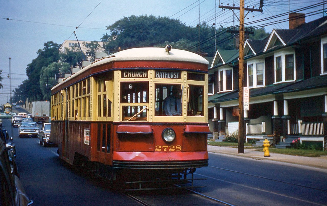 Toronto Transit Commission Peter Witt car 2728 is seen running southbound along Bathurst Street after coming down the hill to Davenport, passing streetside houses on the right and the TTC's Hillcrest Shops (out of frame) to the left. The Bathurst streetcar route was frequently home to Witts for some years. 2728 is running on the branch that ran from St. Clair Avenue south to Church Street via Bathurst, looping on Adelaide, Church and King at the south end before heading back north.