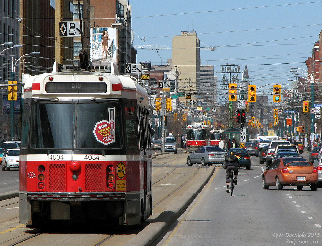Running, Cycling, Driving, Riding. A TTC CLRV heads north on Spadina amid cyclists, pedestrians, auto traffic, and other streetcars.