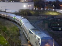 Amtrak's Maple Leaf, the daily New York train, reverses back to Union Station after turning on the wye at VIA's Mimico yard.  Power is Amtrak 3, a GE P42DC.