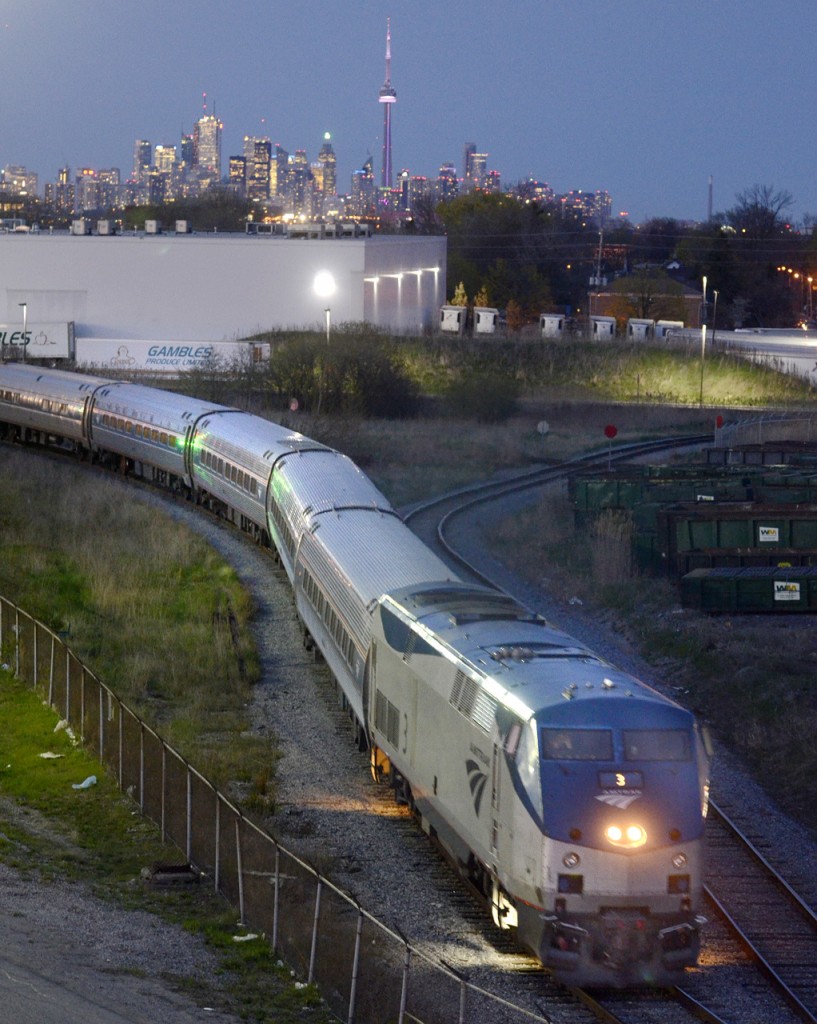 Amtrak's Maple Leaf, the daily New York train, reverses back to Union Station after turning on the wye at VIA's Mimico yard.  Power is Amtrak 3, a GE P42DC.