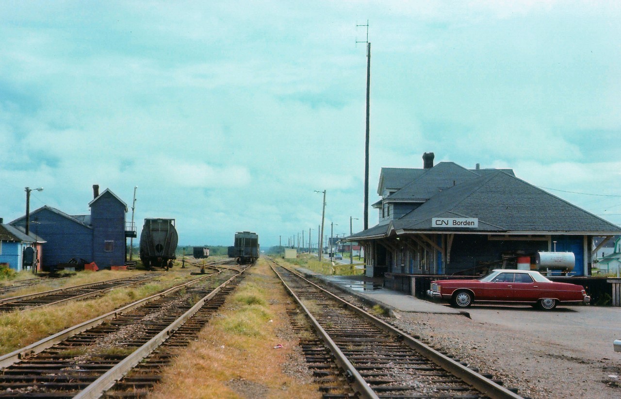 The railroads have been gone from Prince Edward Island for over 25 years. This image, like something out of the Canadian prairies, today shows not a trace of what used to be. Station, yard, trackage and outbuildings all vanished. New development is encroaching the area. It looks so nice and quaint in this photograph, not unlike the Island itself. The station appears neat and tidy, showing a lot of pride being taken in maintaining the surroundings, something we rarely see anymore. Thats probably the Agent's car parked to the side. Compared to today's offerings, it looks like a barge out of the Northumberland Strait. L-o-n-g or what? :O)