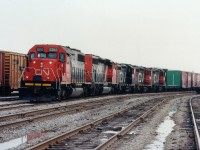 Once an interesting train, CN #448 ran daily from Niagara Falls to Toronto, returning as #449. It worked local traffic along the way. This became part of history due to operational changes when the Southern Ontario Rwy took over operation of Hamilton's CN Stuart St. yard near the end of 1997. In this image, captured in the heart of the old Niagara Falls yard, we see #448 awaiting departure. Behind SD40-2 5365 and SD40-2(W) 5314 we have three of the only eight "Sweeps" (SW & GP) on the roster, the CN 7101, 7103 and 7102 product of remanufactured SW1200RS with some internal components from GP9s, and, most noticeably, the hood. The series 7100-7107, entering the roster in the 1985-1987 period, was sold in its' entirety to CANAC in 2000. The SDs were retired in 2007 and the yard ripped up beginning around that time as well. Nice train on a dull day.