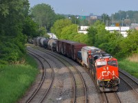 <b>Some sun at the right time.</b> CN 2864 & CN 2860 lead CN 309 away from a crew change at Turcot West on a mostly rainy day. Thankfully the sun came out for a few minutes when CN 309 passed through Montreal West.