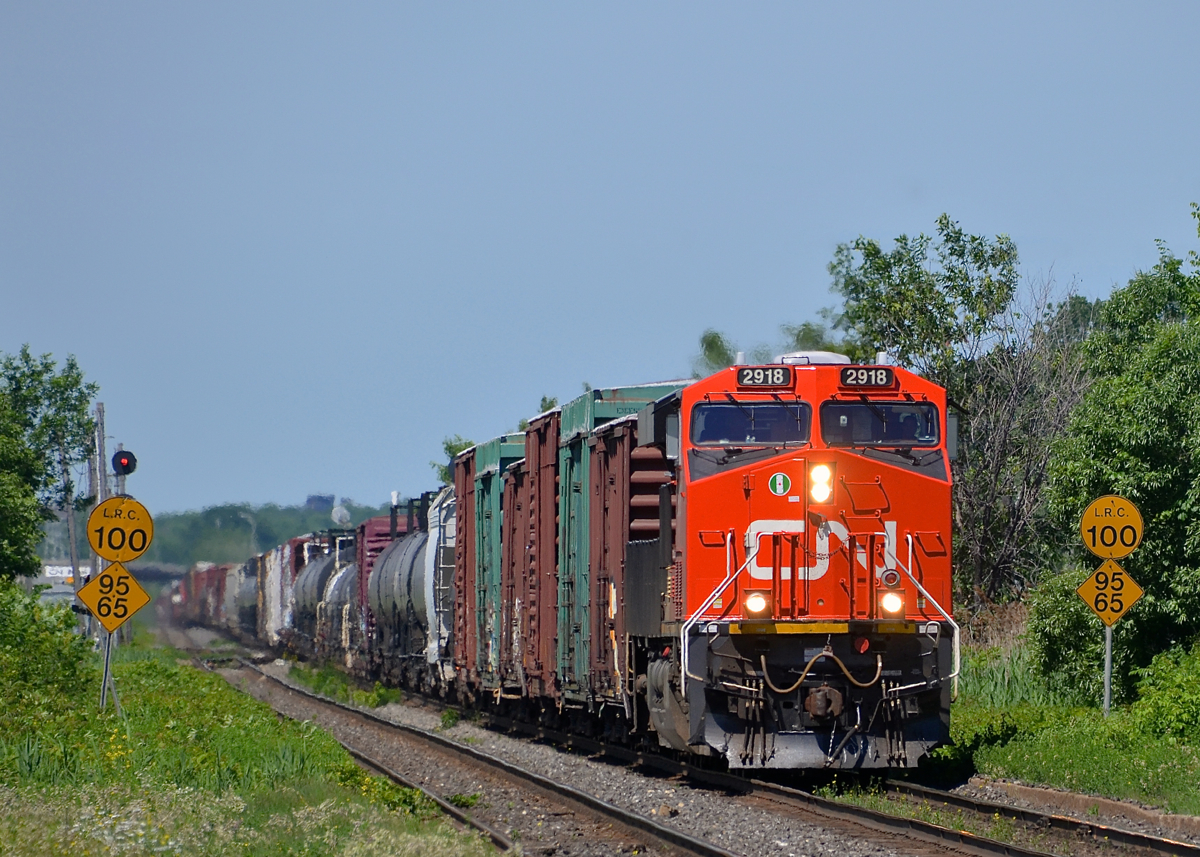 CN 368 has shiny ES44AC CN 2918 leading as it passes the speed limit signs at Dorval. Operating mid-train is older ES44DC CN 2294.