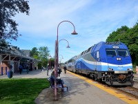 <b>The start of another work day.</b> In a scene played out in hundreds of towns across North America every weekday morning, a commuter train is arriving to take people downtown. In this case AMT 112 from Hudson is bound for downtown Montreal as it passes Montreal West Station with dual mode engine AMT 1367 leading. In a few seconds the train will stop and more passengers will board.