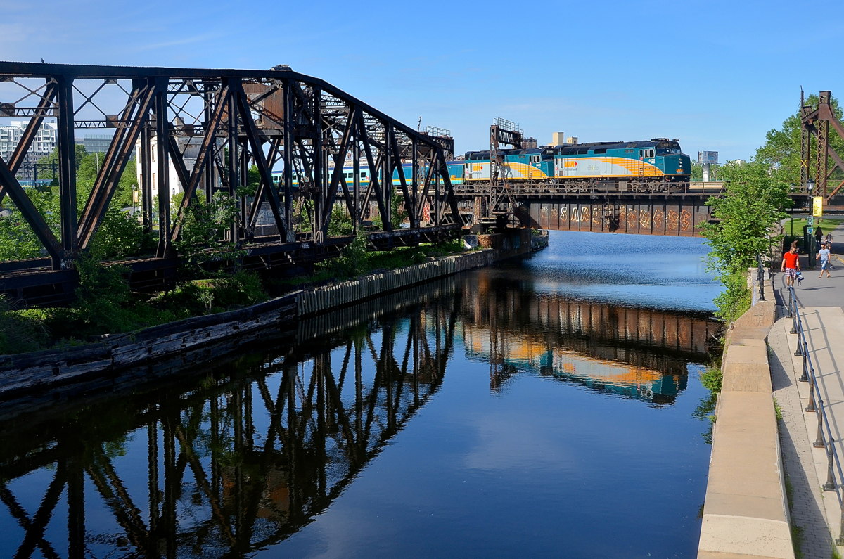 VIA 6428 & VIA 6445 back up over the Lachine canal with VIA 14 in tow on a mostly sunny evening. At the other end of the train is Park car Evangeline Park.