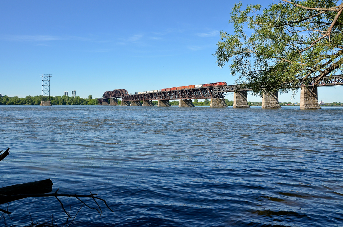 CP 8820 & CP 9804 lead CN 253 over the St-Lawrence river after waiting for the Seaway bridge to go back down after a boat passed. The Seaway bridge is visible in the distance at left.