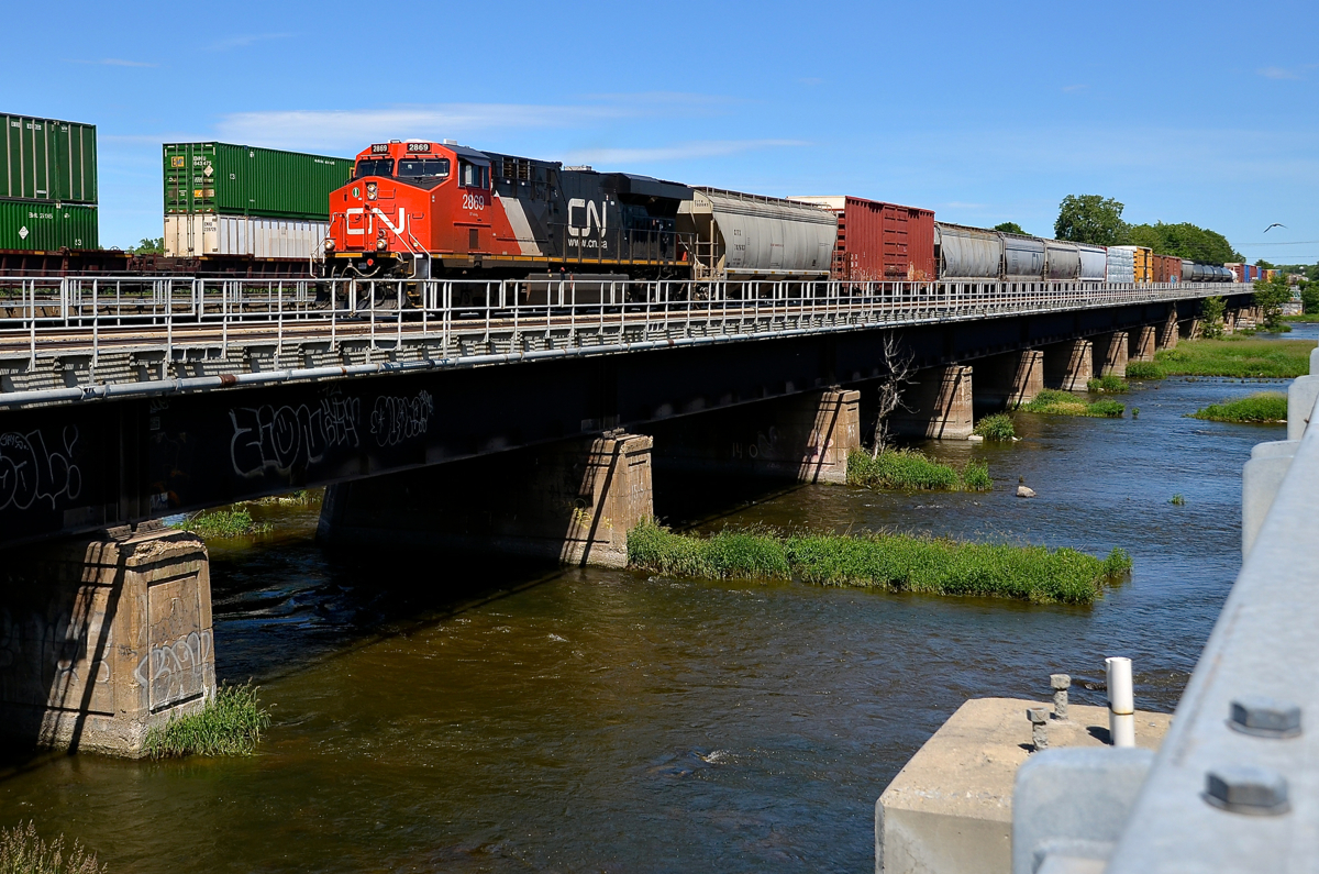 CN 377 with 188 cars total is passing through Dorion with two AC units (CN 2869 & CN 8101 mid-train). He would not make it far as a bad order car would require a setoff at Coteau. CP 143 is passing at left on the parallel CP Vaudreuil sub.