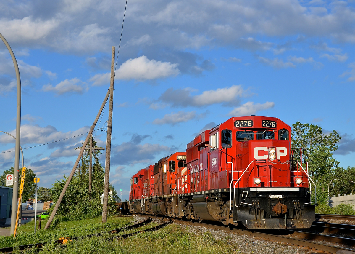 An SD40-2 sandwich and a wave from the conductor. CP 133 (the Expressway) is through Dorval with an all-EMD lashup which consists of an SD40-2 sandwiched by two much nwer GP20C-ECO's (CP 2276, CP 5935 & CP 2250) as the conductor waves from the lead unit