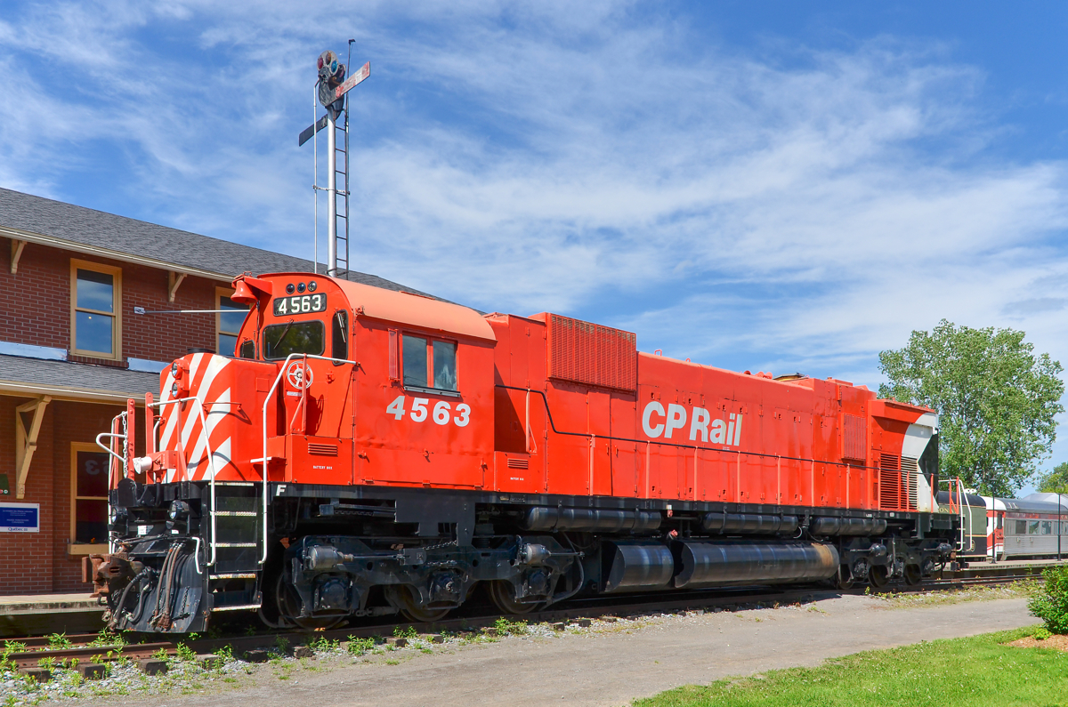 A semaphore and an MLW. CP 4563 (an MLW M630 built in 1969 as CP 4575) rests in front of the Hays station at Exporail. In the background is a semaphore signal.