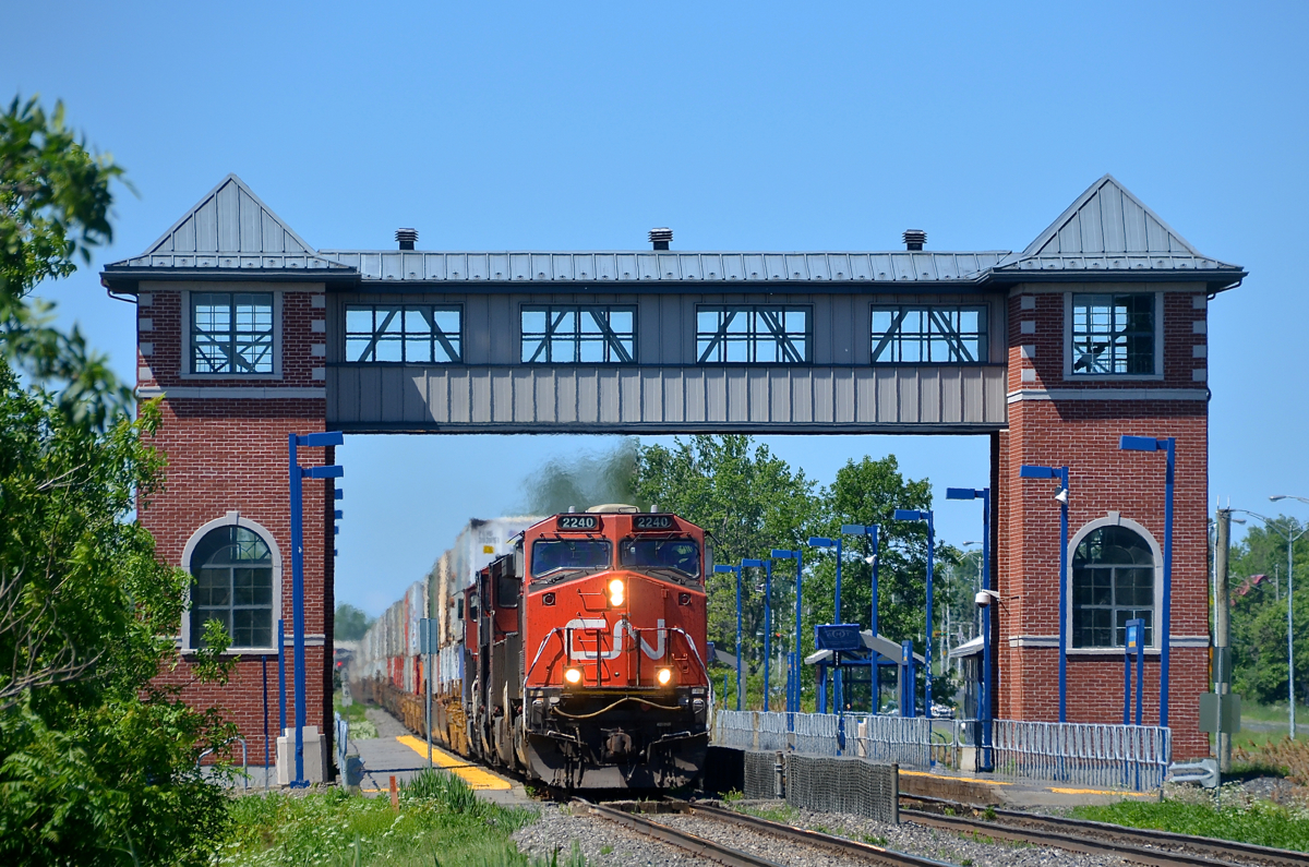 CN 120 past an unusual looking station.CN 120 is passing the unique looking Saint-Basile-le-Grand AMT commuter station with CN 2240, CN 2500, CN 2303 & CN 5745 as power.