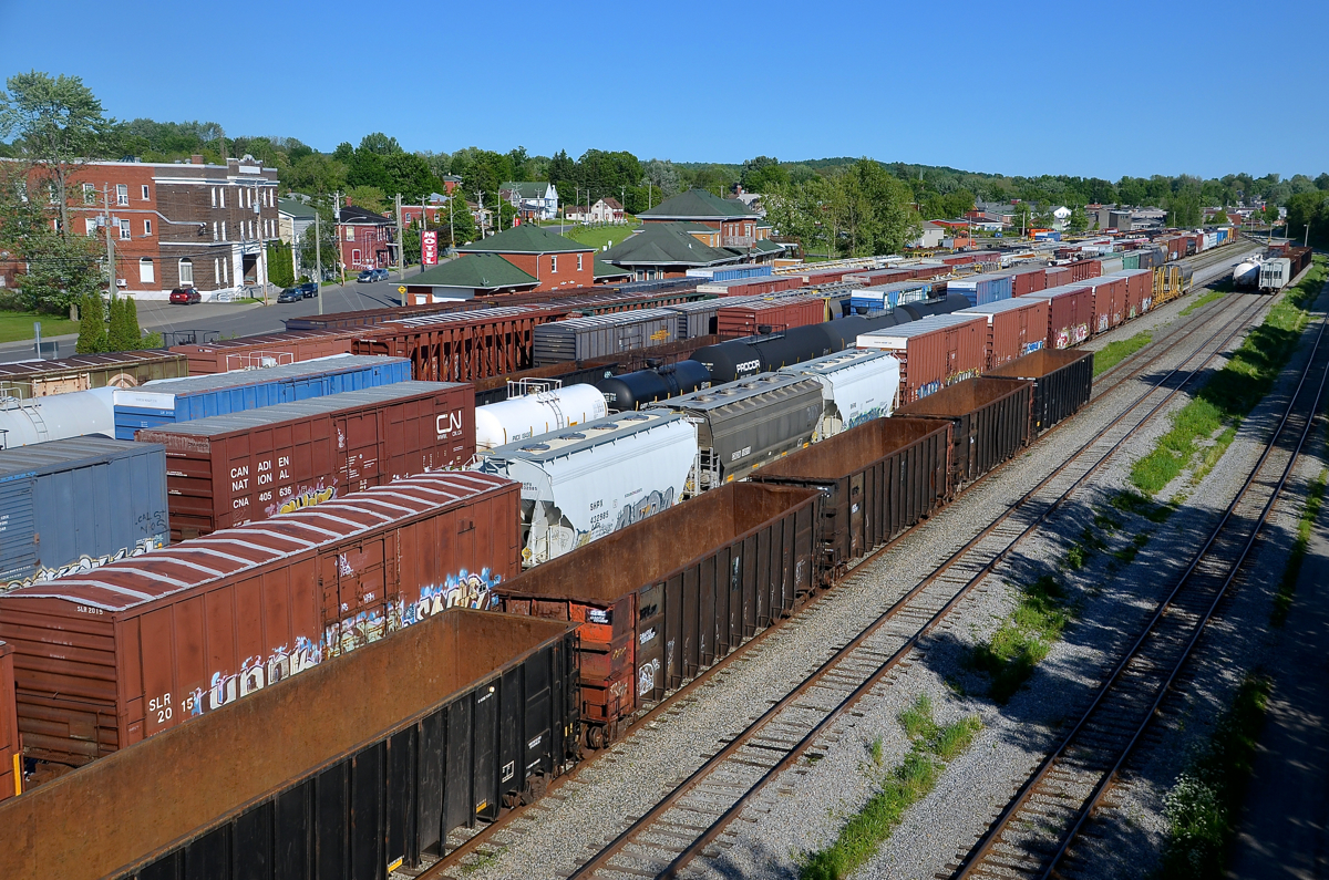 The St. Lawrence and Atlantic Railroad yard in Richmond is rather full in this shot. CN 394 is about to arrive from Montreal and after dropping off his train he will pick up three of these tracks and head back to Montreal as CN 393 with 99 cars. In the background is the ex-Grand Trunk station. Richmond was once an important centre on the Grand Trunk, with tracks heading north to Quebec City and southeast to Portland, Maine.