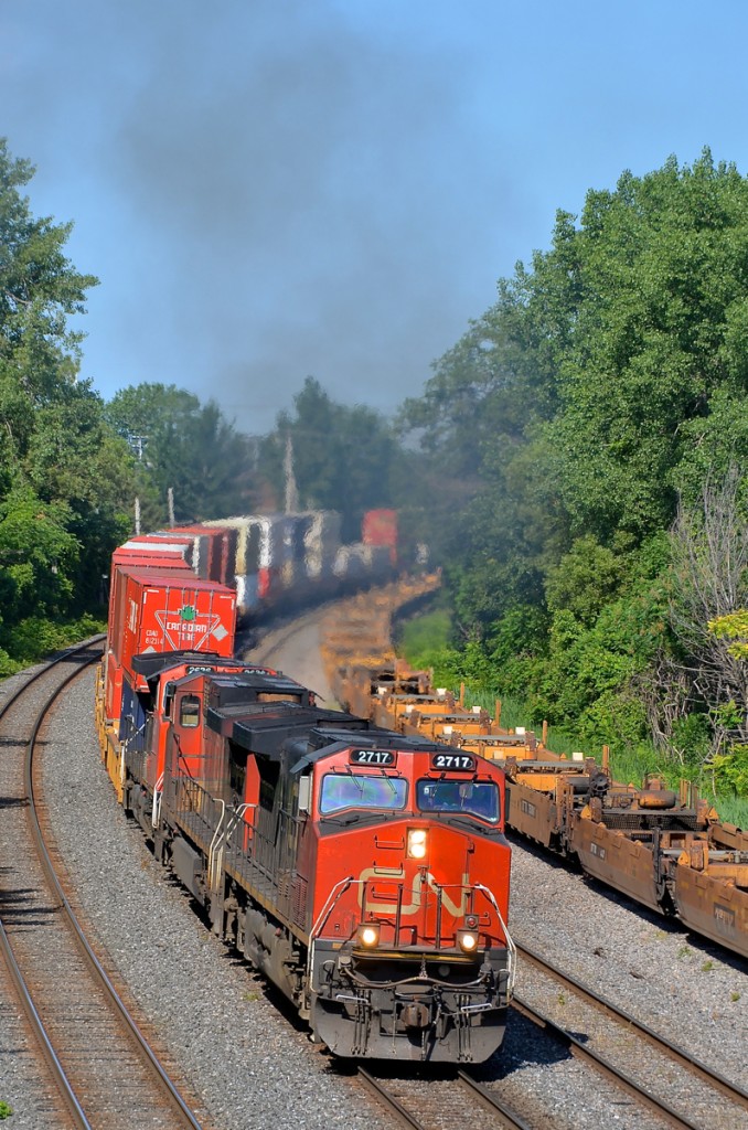 A trio of Dash9's (IC 2717, CN 2699 & CN 2636) lead CN 120 around a curve on the Montreal sub. The third unit is isolated so the other two are smoking it up in true GE fashion.