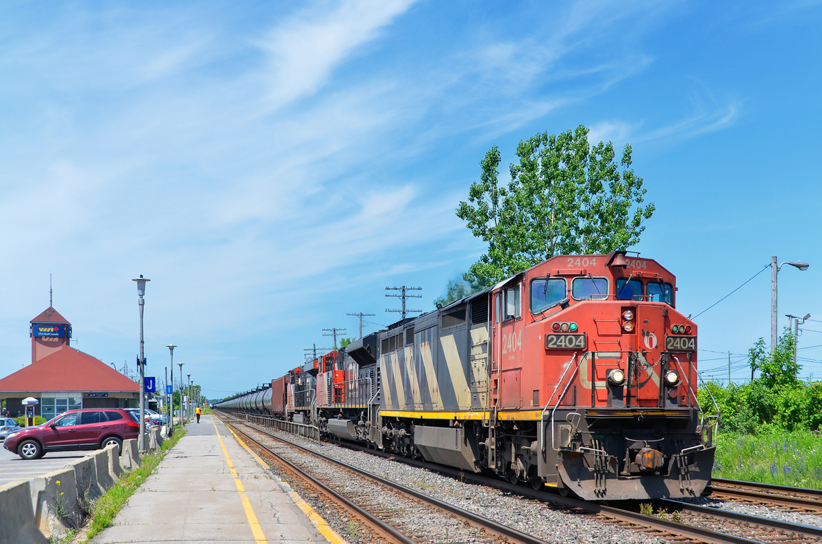 Class lights lit = check. CN 720 has a nice zebra striped cowl leading (CN 2404) with its green class lights lit as it passes through the VIA Dorval station. Trailing are CN 8918 & CN 2298. CN 720 is a crude oil train bound for Rivière-des-Prairies in east end Montreal.