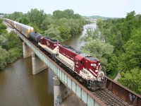 Ontario Southland GP7s 383 and 378 rumble across the Thames River bridge in Woodstock with a collection of empty autoracks for the CAMI car plant in Ingersoll.