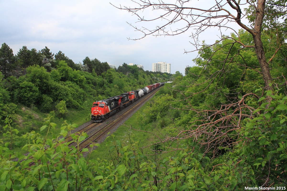 A westbound 3 locomotive manifest train ducks under the Hilda Ave overpass as the surrounding trees shine green. Sometimes I find it hard to believe we're already in June of 2015!