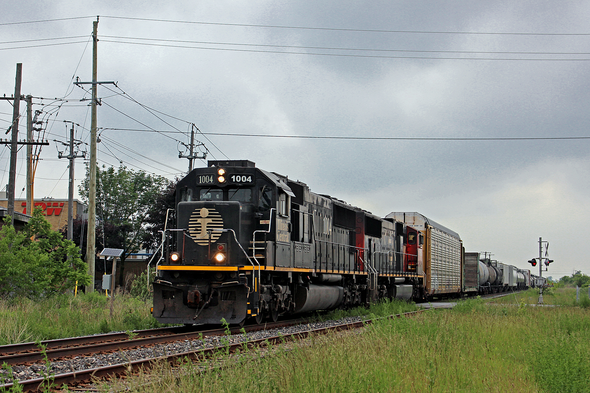 CN 330 effortlessly rips over the Louth Street crossing in St. Catharines with a Death Star in the lead. Trailing is CN 5795, and a short train in tow. 330 is making good time, passing through a little before 6pm.