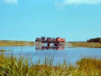 I posted another image of this little caboose hop a couple of years ago, but the uniqueness of the operation deserves second look. Here are CN 70-tonners #30 and #40 returning to Charlottetown from Souris with their wooden caboose in tow. Like a scene from the steam days, this caboose actually has lantern markers on the end. The bridge is over the mouth of the Midgell River, as slow and peaceful as the Island itself. Beyond is St. Peters Bay, and beyond it, the Gulf.  Despite the 60 lb (I think) rail, the little train really opened-it-up along this stretch of track; memory fails me but judging by the whiffs of exhaust they might have reached 25 miles per hour.  It is a real shame railroading days like this are long gone, and I feel regret for not catching more activity on the Island, but in honest recall know I did the best I could in the time I had. Not much happened out there.  I had gone down to the Shop in Charlottetown early morning to see what time the first train to Souris in 3 months (empty reefers for potatoes) was going to be leaving and it had already departed, pre-dawn. So I was able to meet it in Souris, and grabbed a few photos of it on the way back. I don't know why I didn't plan better, but like many of us amateurs of the day I allowed myself to run out of film. Mad dash to a store fetched me something called "3-M" rather than Kodak. It had to do. Actually, turned out not that bad. The camera, btw, was an old Pentax K-1000.  CN 1750 and 1786 departed PEI by ferry with the last train on the 28th of December, 1989. Now, the old line is mostly the Confederation Hiking Trail. Still good enough to make me want to go back. The locomotives? Both #30 and 40 were retired by 1983, with #30 going to the rail museum in Delson, Quebec, in 1984.