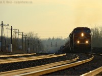<b>On golden rails</b> CP Train 246 is riding the high-iron in style, with the first light of the day gilding the sky, and the rails, a deep golden hue. Cresting the grade at Guelph Junction, the crew of Train 246 will trade their royal rails for sunglasses as the railway makes a sharp turn into the sun southward toward Hamilton and Buffalo. Like a roller coaster, the crew of 246 has two more grades to conquer before reaching Buffalo, Essar Steel loads on the head end will challenge downgrade at Waterdown, and the extra tonnage lifted at Hamilton will resist the upward climb to Vinemount, the journey only half completed to Buffalo.<br><br>Much of this traffic used to take the TH&B Route to Toronto - and one can see why the <a href=http://www.thbrailway.ca target=_blank> TH&B</a> <a href=http://www.railpictures.ca/searchresults?query=Toronto+Hamilton+and+Buffalo+-imagesize:200x150+-imagesize:930x170+-imagesize:728x90+-imagesize:720x90+-imagesize16x16+-imagesize:200x130+-imagesize:200x133+-imagesize:200x136+-imagesize:200x151+-imagesize:200x132 target=_blank> (more on rp.ca) </a> opted to build a route to Toronto parallel to the Oakville sub. (This was on the drawing board, but the CNR decided to grant rights to avoid the direct competition!). Trains would have only had one major grade instead of three. In 2010 CP made their choice to cancel the Joint Section - and as a result we get to witness the sights, and sounds of high-iron drama: Pushers at Hamilton for Waterdown, and more trains running up the hill at Campbellville. 