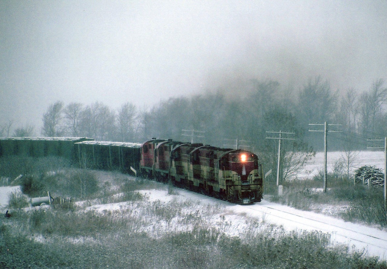 One of those really crappy days when everything seems to turn to shades of gray; the TH&B sends a rock extra up the hill southward to Port Maitland. Only unit identified is leader #73, probably on account pen failure when I went to jot the numbers on my hand.  It is wet, sticky and about -1C. Wind whipped snow is sticking to the poles. Down the hill at Aberdeen earlier, about 14 miles back,  it was but wet slush.