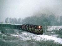 One of those really crappy days when everything seems to turn to shades of gray; the TH&B sends a rock extra up the hill southward to Port Maitland. Only unit identified is leader #73, probably on account pen failure when I went to jot the numbers on my hand. It is wet, sticky and about -1C. Wind whipped snow is sticking to the poles. Down the hill at Aberdeen earlier, about 14 miles back, it was but wet slush.