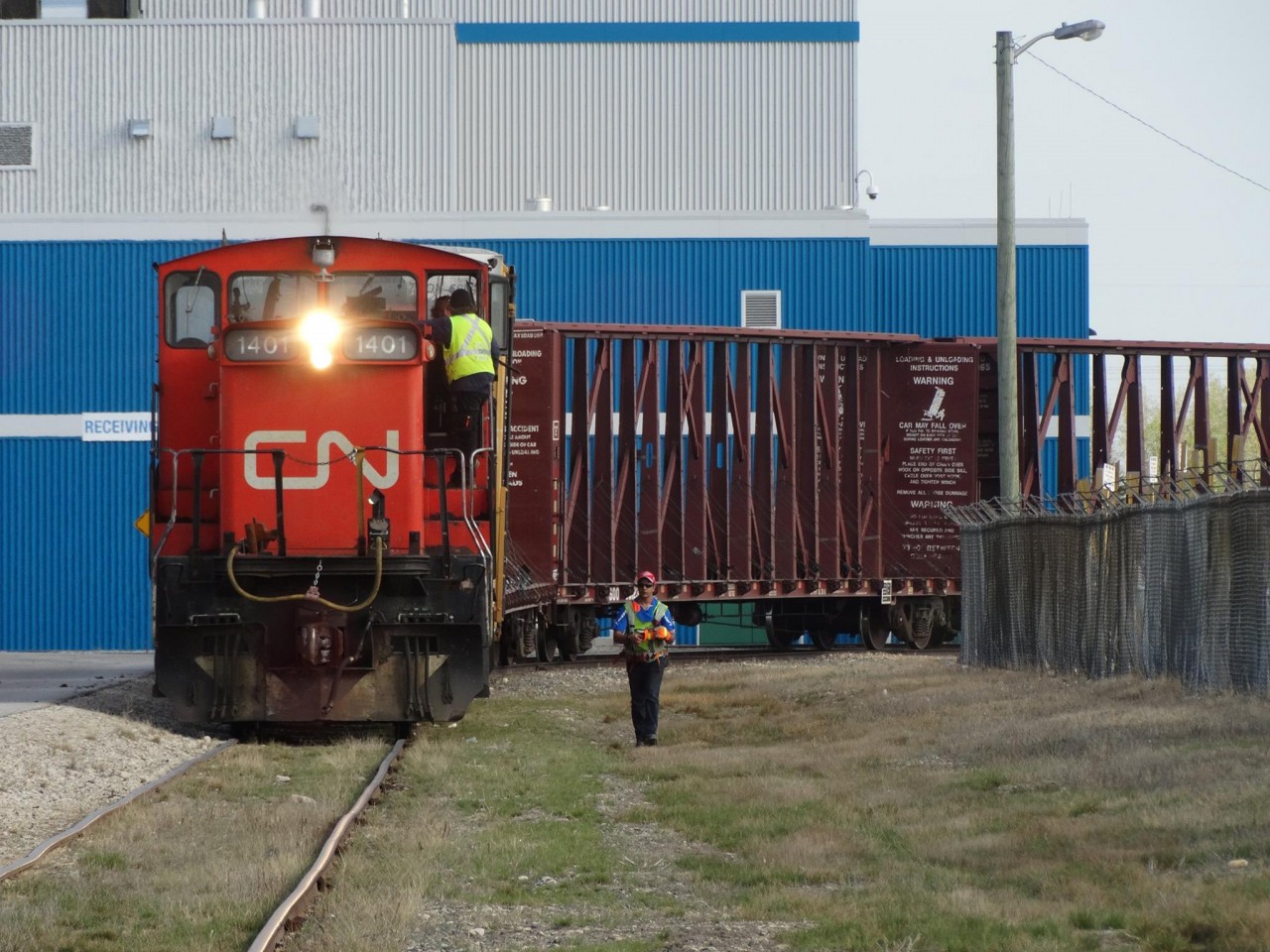 A short local freight waits around a curve for the brakeman to return from throwing a switch behind them.