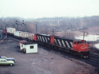 Again, I am out on a damp drizzly morning. Waiting up on the hillside at Bayview Jct for something to happen. After an hours' restlessness, along comes this move. CN 2528,2552 with 3 cars and a caboose. Since I do not have any notes from back then regarding trains or train numbers to and from Niagara, I have no idea what this move was. It has been suggested a transfer to the Hamilton yard facility. Sounds right. So why isn't this handled by a couple of SWs as I was used to seeing? Anyway, this is the "train" of the morning, The 2528 became 3538, was sold to NRE...I'm wondering where it is now......the second MLW M-420(W) 2552 was retired in 1984. Why am I out on such a dreary morning? It was my day off work. You take what you can get.