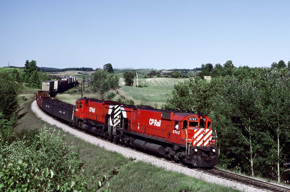 On our Labor day weekend 1978, we walked down the track to a nice curve to setup for the westbound Canadian and were surprised when 2 big consecutively numbered M636's leading an eastbound freight into Toronto showed up first.