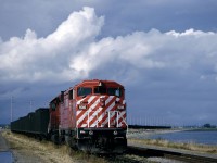 CP #9016 sits waiting for a turn to unload at the Roberts Bank terminal in July 1993.  I had ridden behind the Royal Hudson to Squamish on what had been a very wet afternoon through those clouds in the background of this scene. But when the sun popped out driving back toward the States, I decided that the only chance to find anything in that area to take advantage of the clearing skies would be if there was a coal train staged at the port waiting to unload.  I was rewarded with this CP SD40-2F red barn sitting perfectly in the evening sunshine.