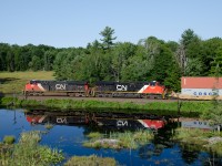 CN 106 with a pair of ES44AC units heads south from Falding toward Dock Siding on a beautiful summer morning.