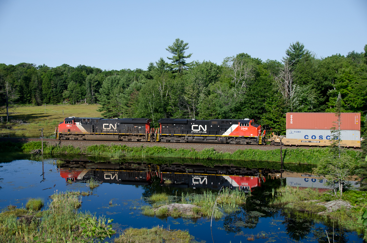 CN 106 with a pair of ES44AC units heads south from Falding toward Dock Siding on a beautiful summer morning.