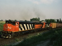 A train that was definitely worth the chase from Bayview! CN HR-616 leads train #414 east on the Halton Sub, the train has just crossed Tremaine Road. Ruining <g> the MLW power set is Bessemer & Lake Erie SD9 829, one of five leased by CN for a few months in 1988.