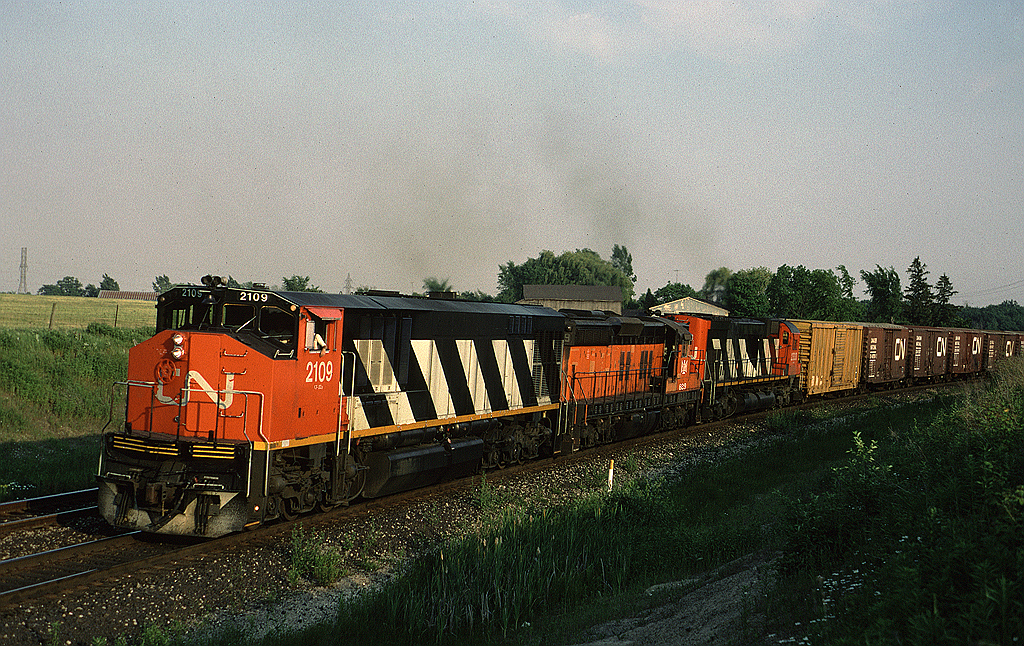 A train that was definitely worth the chase from Bayview! CN HR-616 leads train #414 east on the Halton Sub, the train has just crossed Tremaine Road. Ruining  the MLW power set is Bessemer & Lake Erie SD9 829, one of five leased by CN for a few months in 1988.