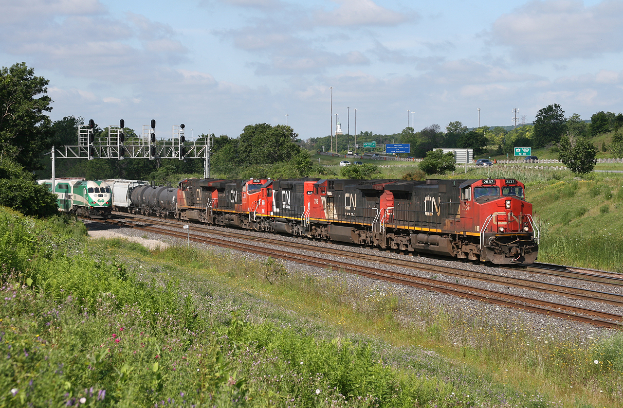 GO 785 scoots through Snake on track 3, as CN M 38461 18 rumbles down track 1 on a humid July morning.  CN 2537, CN 2149, EJE 666, CN 2529 and CN 2296 provide the power for 384, unfortunately the EJE is one of the few that have been repainted!