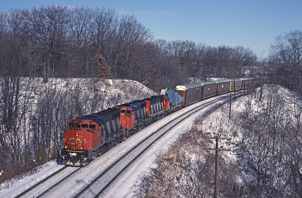 CN GP40-2W 9533 leads another GP40-2W and an MLW with a westbound approaching Bayview. The load in the head end is a set of airplane wings from McDonnell-Douglas plant at Downsview.