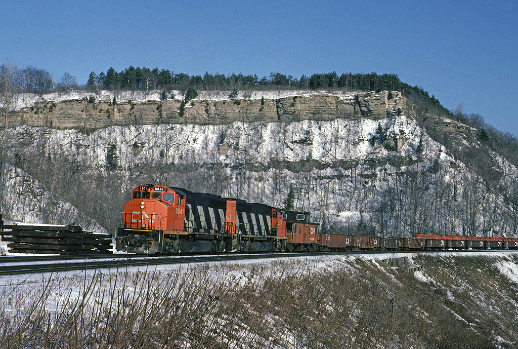 Train #725 was the steel train to Stelco's Lake Erie Works in Nanticoke, often powered as on this day by a pair of GP40-2Ws. It ran with a caboose on both ends to facilitate changing direction in Brantford. There doesn't appear to be any hikers out on the peak today!