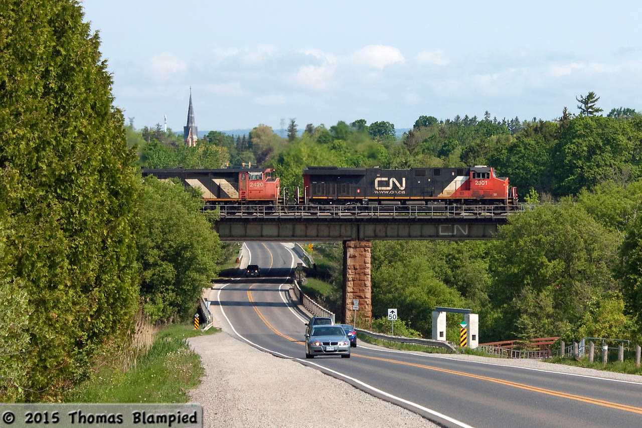 An eastbound freight crosses the bridge over Duffins Creek and the aptly-named Church Street.