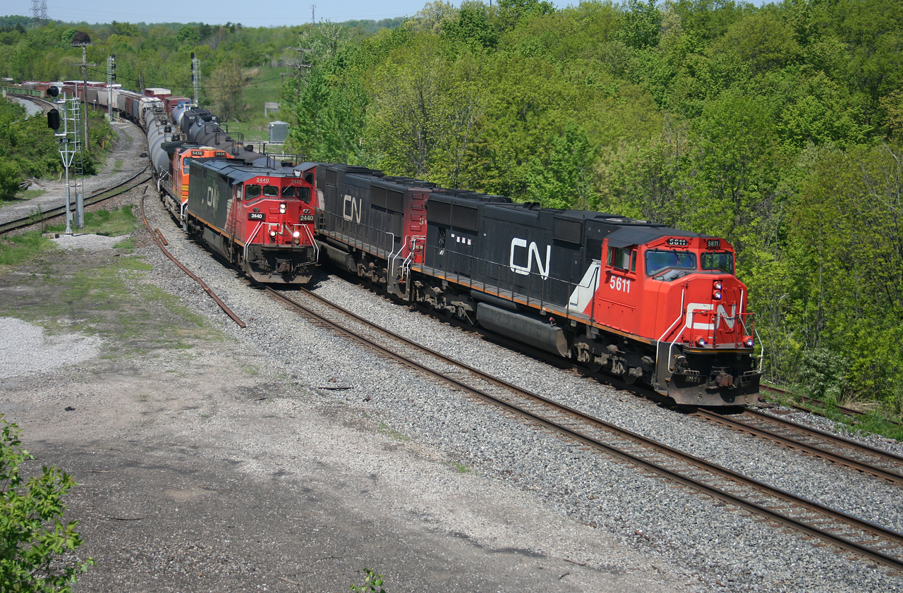 CN X392 led by CN 5611 operating on the north track, overtakes a slower moving M394 with CN 2440 and BNSF 5438.