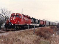 Everything interesting seemed happen on crappy days. This is another one of those infrequent, actually rare, moves in which the Talbotville to Buffalo auto-parts train #328 of old had to detour the Thorold Sub, bypassing Niagara Falls. The Thorold sub connected at Port Robinson, about a mile up the line from where I am capturing this image. A handful of detours in late fall 1996 and early 1997 occurred due to Bridge 6 work block (after AMTK passed) at the Welland Canal. In this shot, the train has just crossed Hwy 20 at Blackhorse Corners; power is CP 5418, NS 4014 and CP 5600. Nice to see that NS x-SOU "baby boat" in consist.