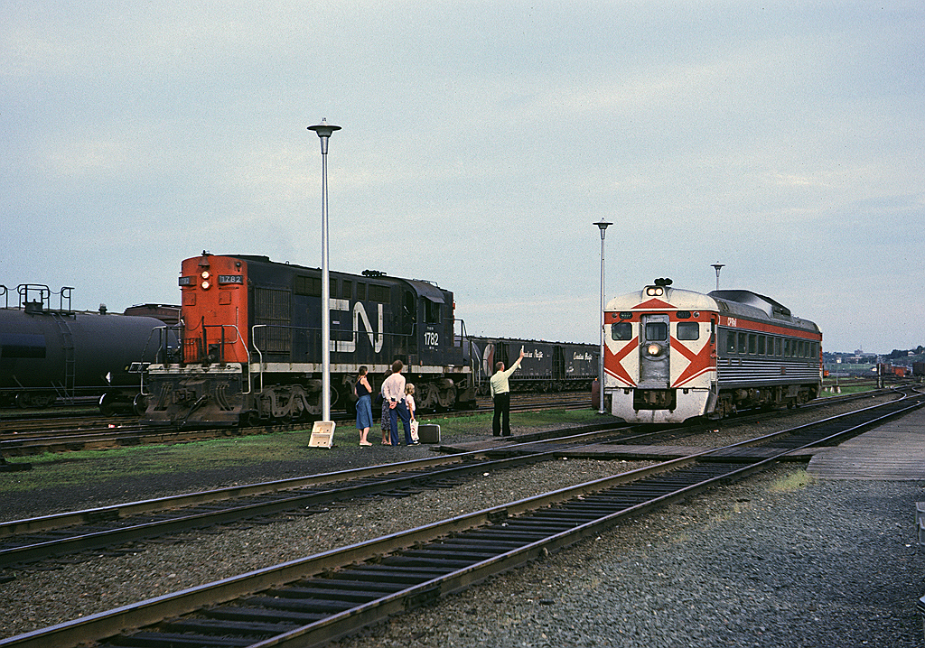 A family waits to board as CP RDC-1 9072 approaches Rockingham station with Dominion Atlantic's Halifax - Yarmouth Dayliner. On an adjacent track CN RSC-14 1782 idles. This locomotive would have worked during the day as the Rockingham yard switcher and will now sit until morning since if I remember correctly this was a day shift only operation. The DAR train will switch to its own track at Windsor Junction about 10 miles to the west.