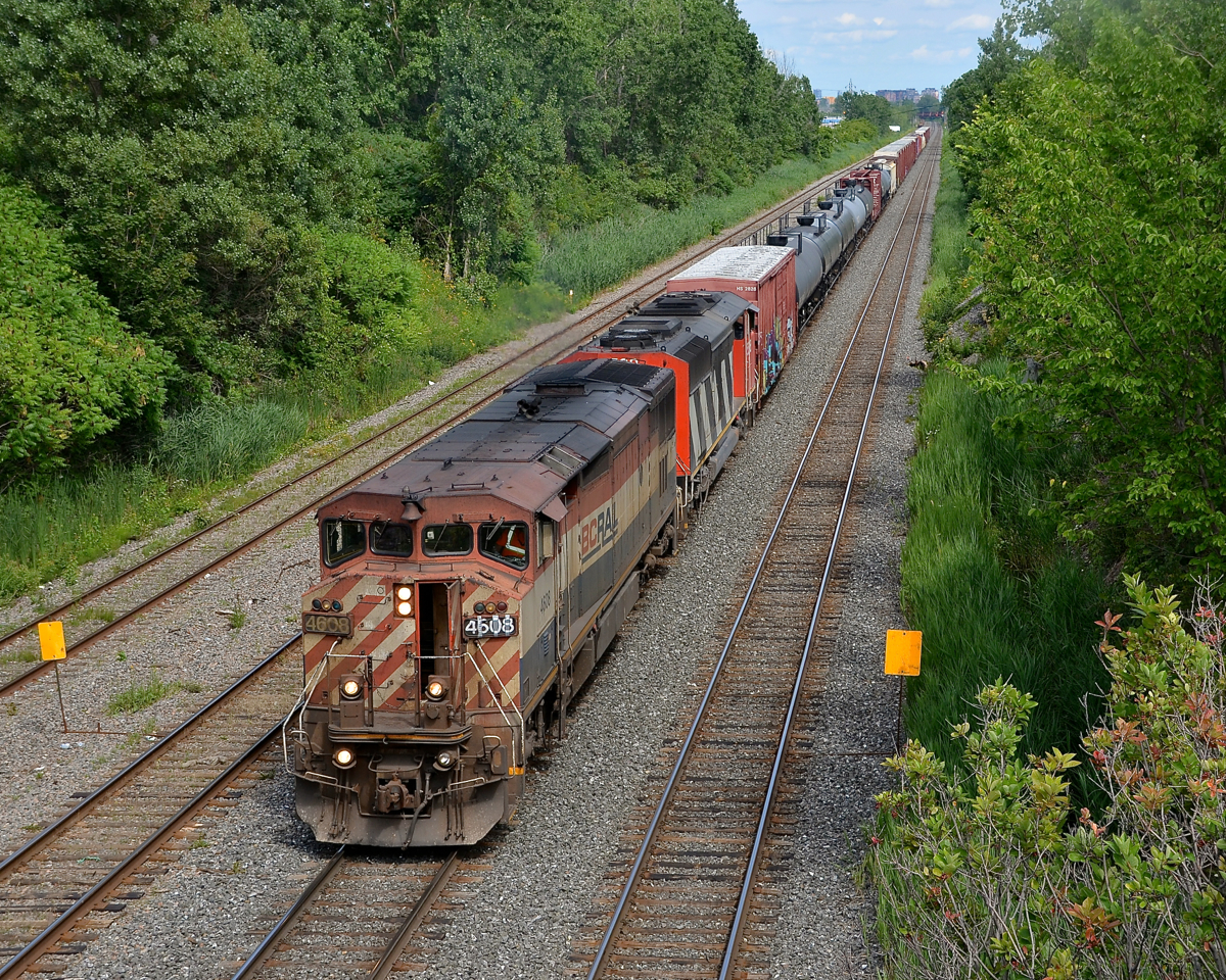 CN 323 has an all-cowl lashup with BCOL 4608 leading CN 5538 as it approaches Taschereau Yard on its way back from St. Albans, Vermont. The left numberboard is held in place by duct tape!