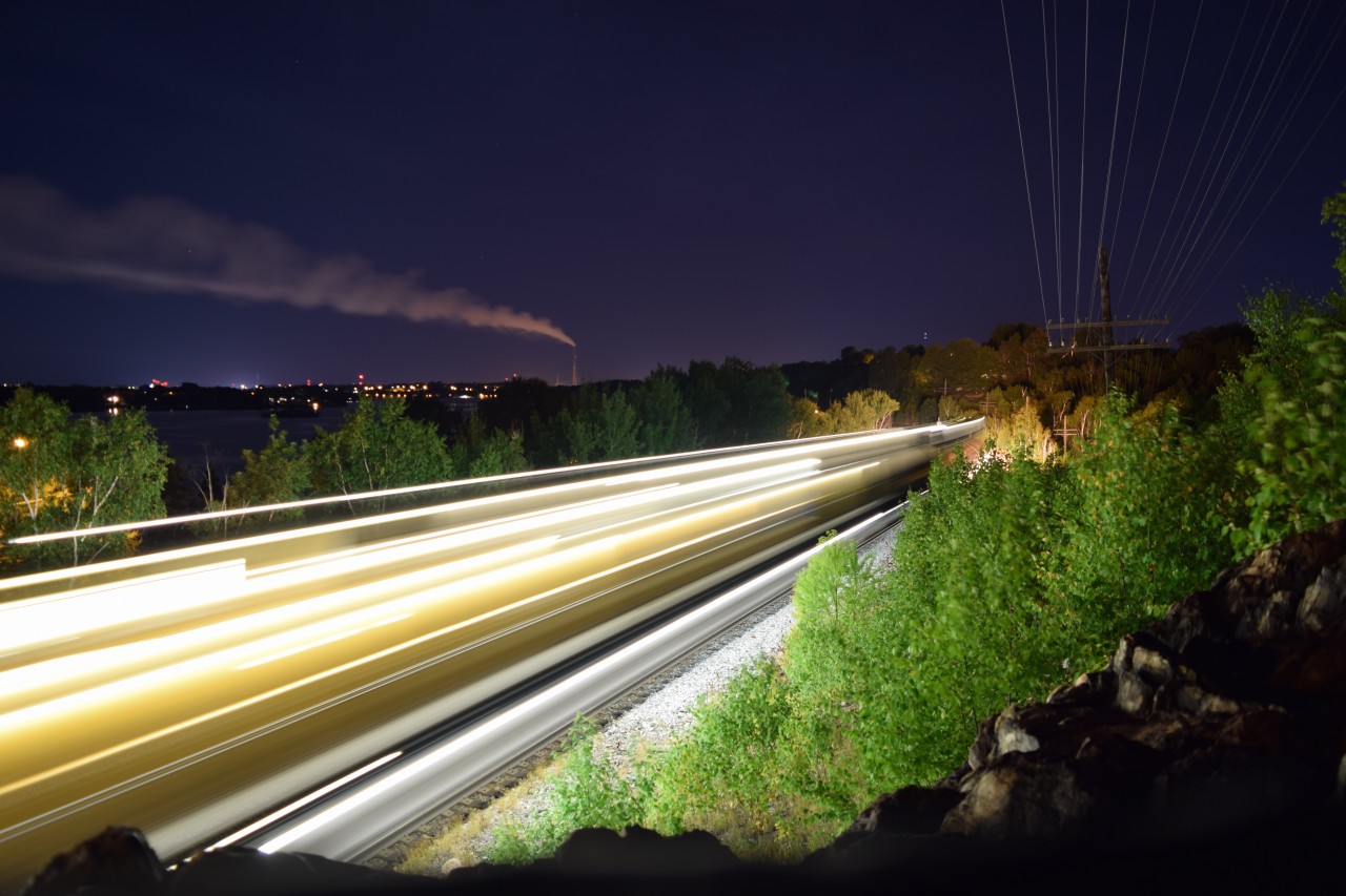 The Loram Rail Grinder makes its' way slowly eastward along the shores of Lake Ramsey on CP's Cartier sub.