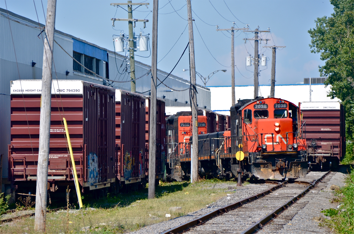 A GP9-slug-GP9 trio (CN 7038, CN 221 & CN 7250) is busy moving cars on a siding off of the Côte De Liesse spur.