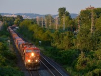 Leaving Montreal about 5 hours later than normal, CP 143 catches last light as it rounds a curve in Pointe-Claire, with the Pointe-Claire Station in the background and Mount-Royal further back. Power is CP 8708 & CP 9634.