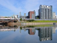 <b>Amtrak heritage, reflected.</b> The southbound <i>Adirondack</i> deadheads towards Montreal's Central Station with heritage unit AMTK 145 pushing, castings its reflection in the Peel Basin along with Montreal's skyline.